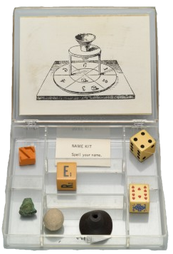 George Brecht (American, 1926–2008). Games and Puzzles (Name Kit) from Fluxkit. 1965, Fluxus Edition announced 1965. Plastic box with two offset labels, containing offset card, ball, rubber object, rubber stamp, stone and three die. Designed and assembled by George Maciunas (American, born Lithuania. 1931–1978). 7/8 x 4 11/16 x 3 15/16" (2.3 x 11.9 x 10 cm) (box, closed). The Gilbert and Lila Silverman Fluxus Collection Gift. © 2011 Artists Rights Society (ARS), New York/VG Bild-Kunst, Germany